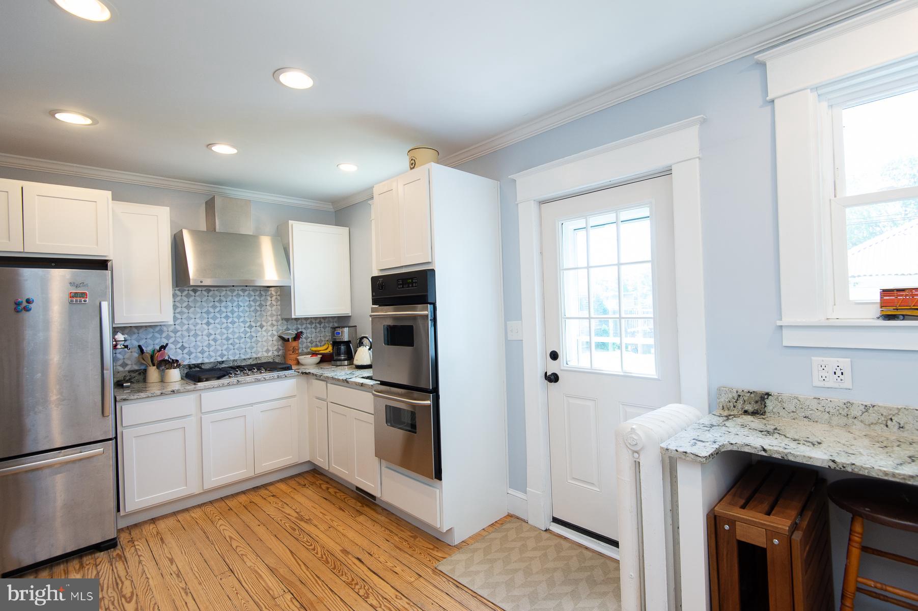 606 Locust Street Cambridge, MD 21613 - Photo 13 of 37 a kitchen with granite countertop a sink stove and refrigerator
