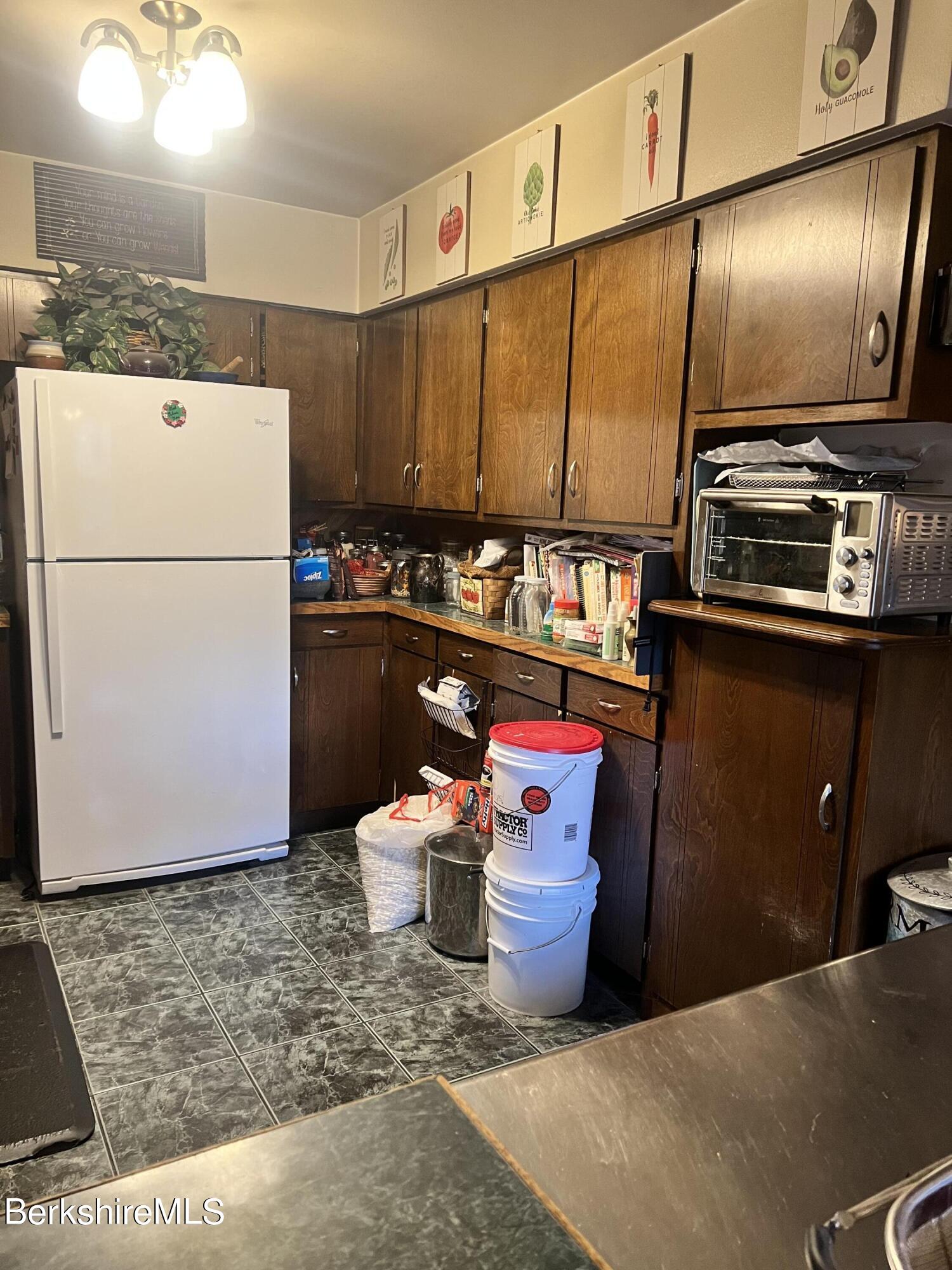 82 River Road Savoy, MA 01256 - Photo 3 of 27 a kitchen with stainless steel appliances a refrigerator a sink and wooden cabinets