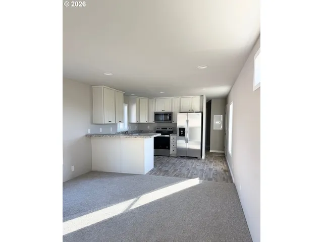 a kitchen with kitchen island granite countertop a sink cabinets and stainless steel appliances