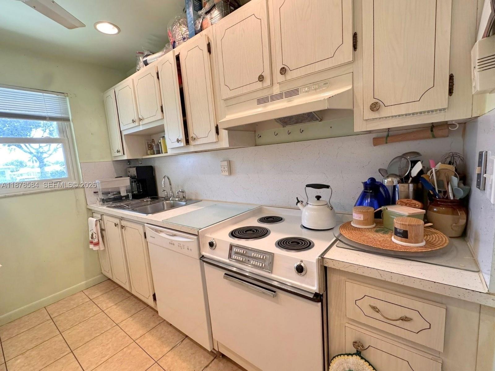 285 North High Point, Unit A Boynton Beach, FL 33435 - Photo 14 of 32 a kitchen with white cabinets and white appliances