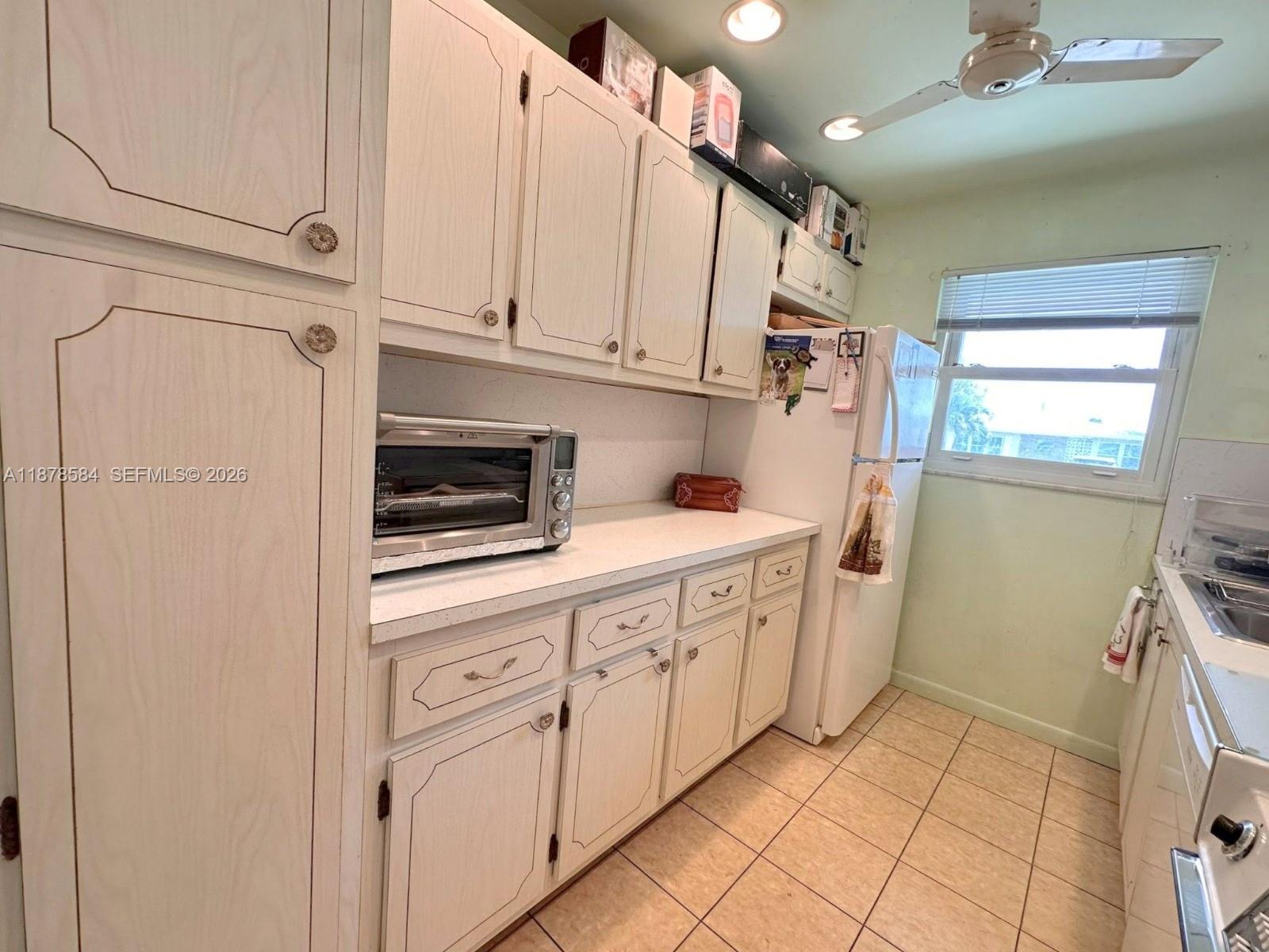 285 North High Point, Unit A Boynton Beach, FL 33435 - Photo 15 of 32 a kitchen with white cabinets and white appliances