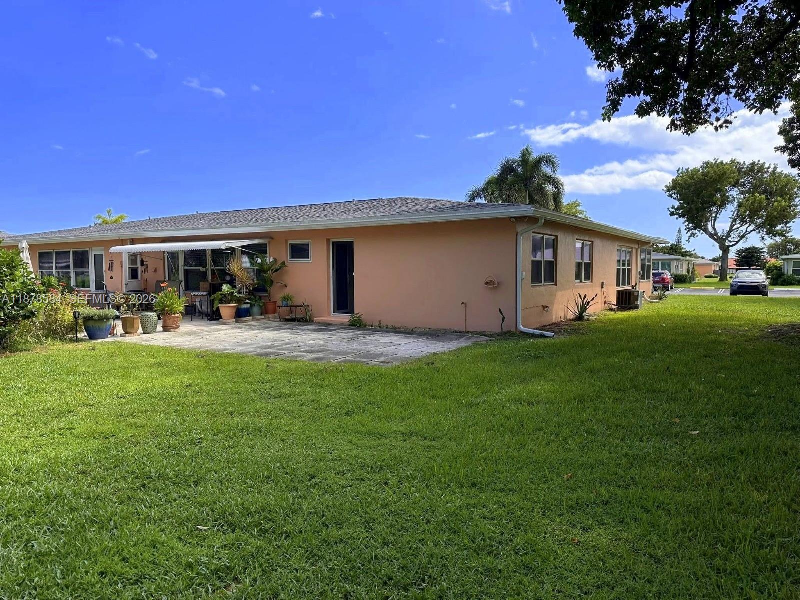 285 North High Point, Unit A Boynton Beach, FL 33435 - Photo 25 of 32 a view of a white house with a big yard and potted plants