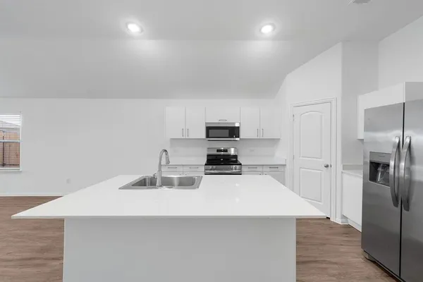 a kitchen with stainless steel appliances a refrigerator and a stove top oven