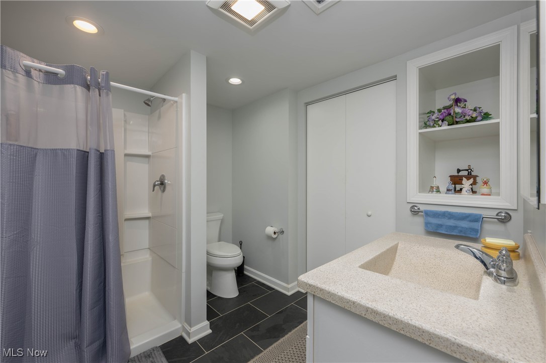 3205 Hemphill Road Barberton, OH 44203 - Photo 12 of 22 Bathroom featuring toilet, a shower with curtain, vanity, and tile patterned floors