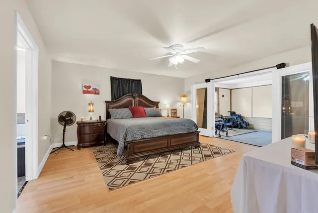 a bedroom with a bed and a large mirror with a bookshelf