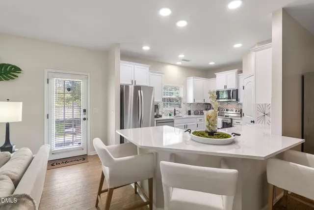 a kitchen with a dining table chairs and refrigerator