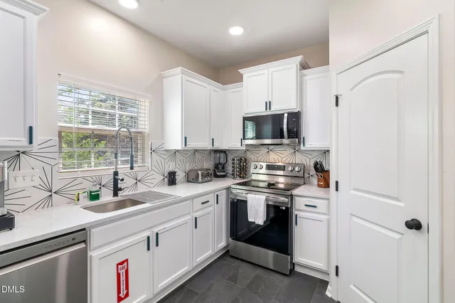 a kitchen with a sink stove top oven and refrigerator