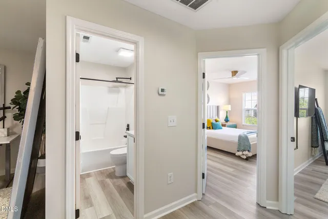 a bathroom with a tub shower and bedroom view