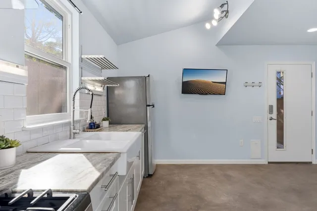 a kitchen with stainless steel appliances granite countertop a sink a stove and a granite counter tops with a window