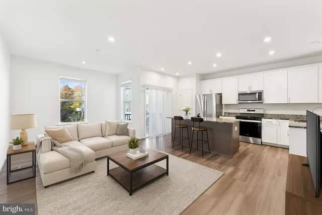 a living room with furniture and kitchen view