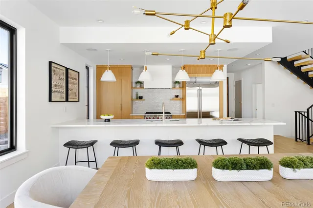 a kitchen with stainless steel appliances granite countertop a refrigerator a stove and a sink