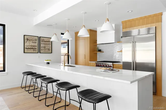 a kitchen with stainless steel appliances a stove a sink and a refrigerator