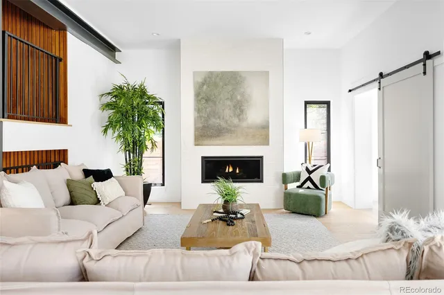 a living room with furniture potted plant and a large window