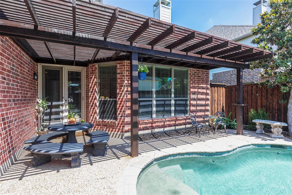 1217 Windmere Way Allen, TX 75013 - Photo 3 of 38 Framed by rich brick accents and architectural beams, the covered outdoor living space blends comfort and character just steps from the water’s edge.