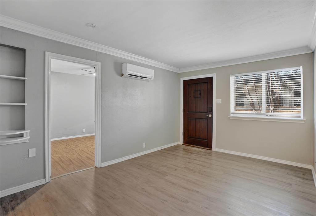 3310 Douglas Avenue, Unit B Dallas, TX 75219 - Photo 10 of 11 a view of an empty room with wooden floor and windows