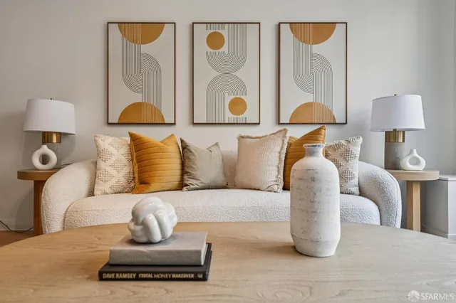 a living room with furniture kitchen view and a wooden floor