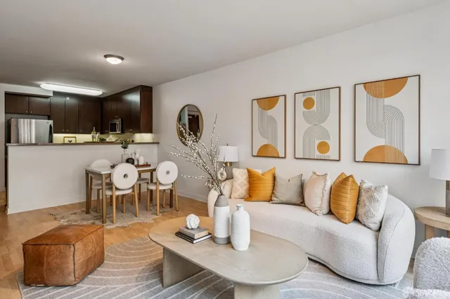 a living room with furniture a large window and kitchen view