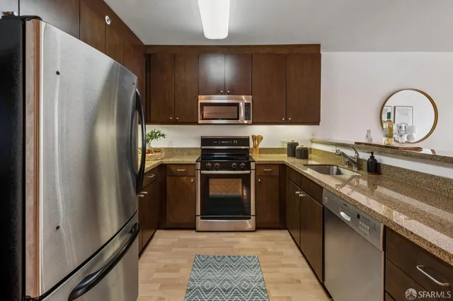a kitchen with granite countertop stainless steel appliances and wooden cabinets