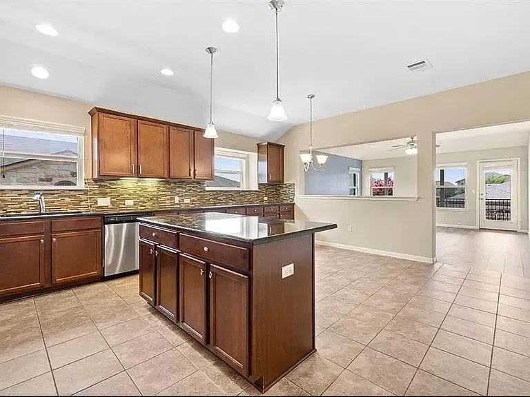 417 Tula Trail Leander, TX 78641 - Photo 4 of 24 a kitchen with stainless steel appliances granite countertop a stove and a sink
