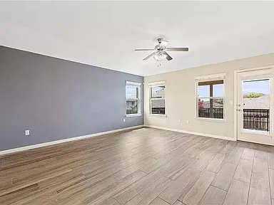 417 Tula Trail Leander, TX 78641 - Photo 6 of 24 a view of an empty room with window and wooden floor