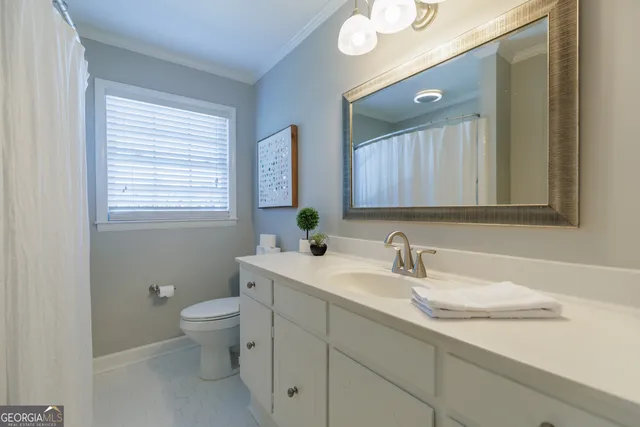 a bathroom with a toilet sink and mirror