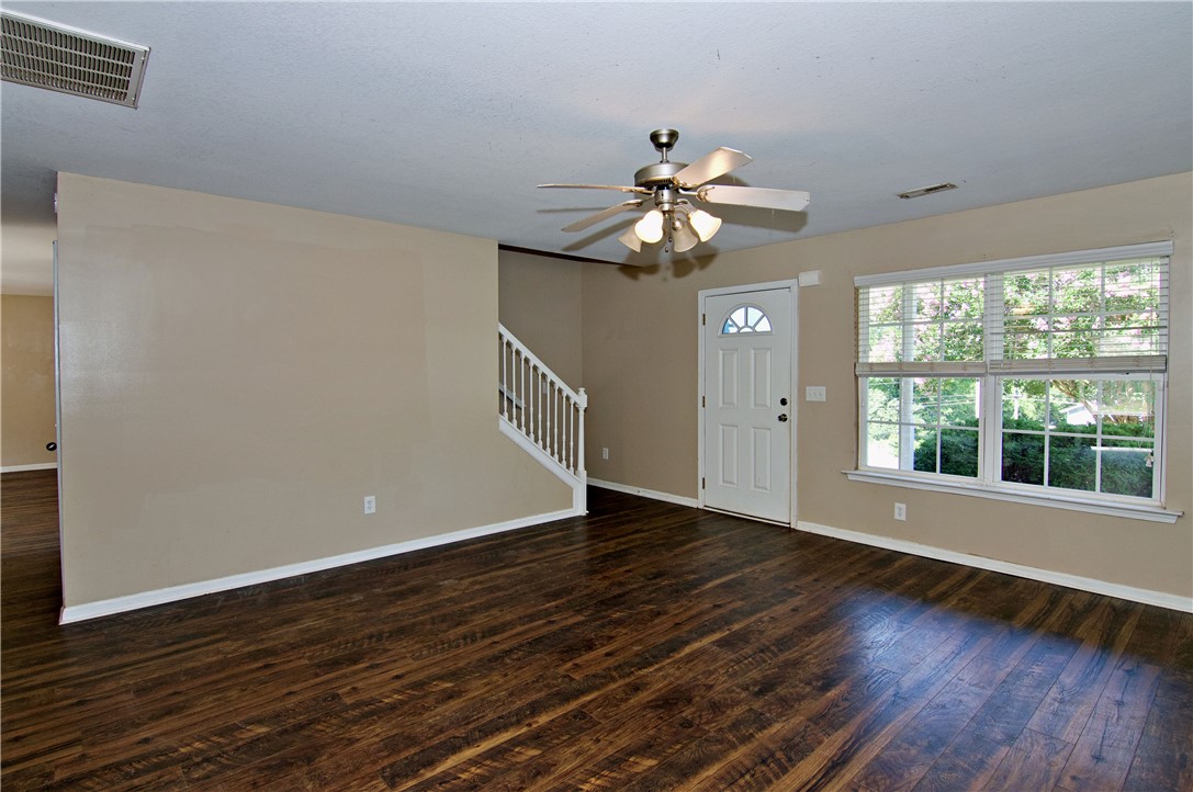 305 North Chestnut Street Seneca, SC 29678 - Photo 8 of 44 Warm wood flooring extends throughout this inviting living space, bathed in natural light from the large window.