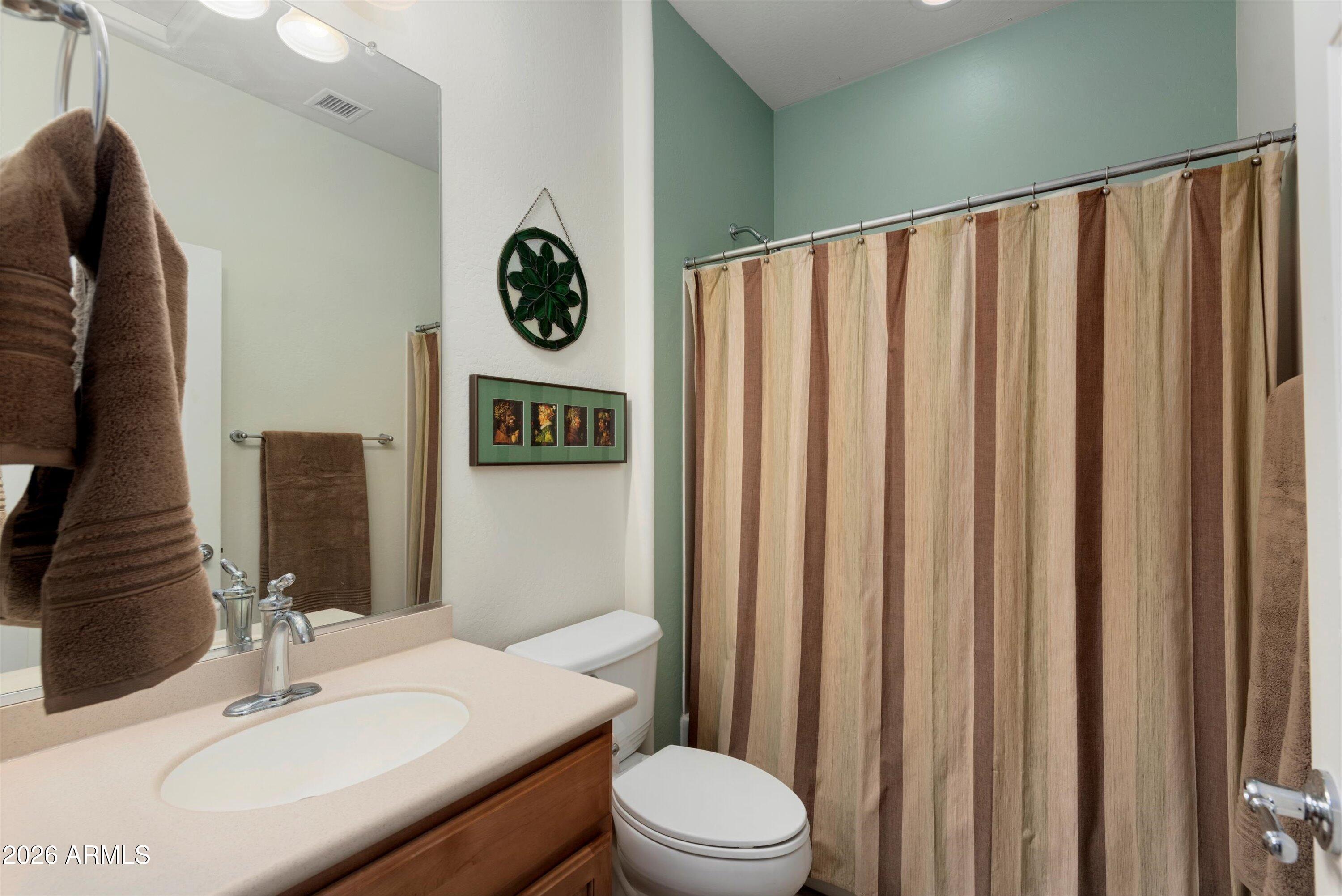 21613 North 261st Avenue Buckeye, AZ 85396 - Photo 21 of 52 a bathroom with a sink vanity mirror and toilet