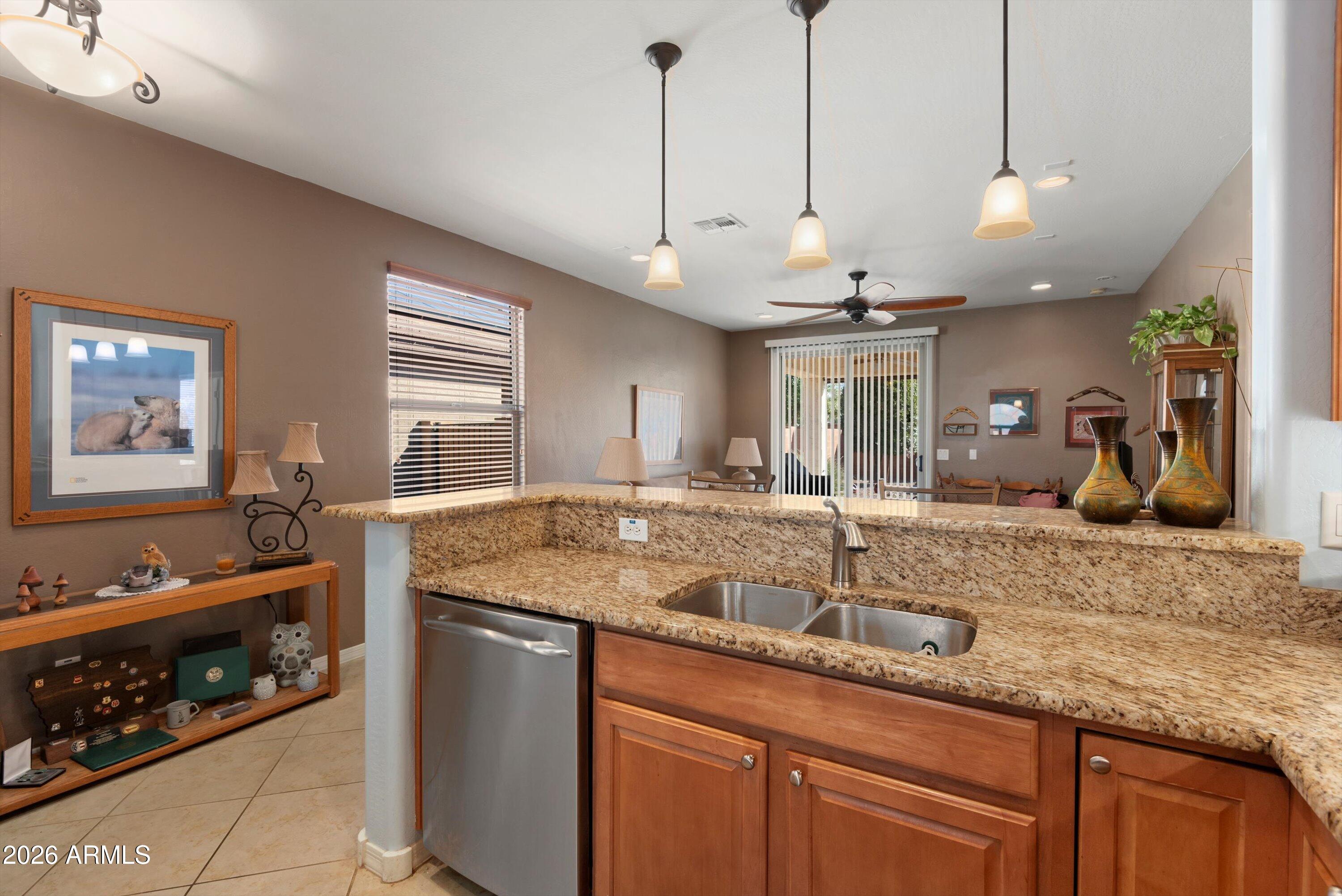 21613 North 261st Avenue Buckeye, AZ 85396 - Photo 7 of 52 a kitchen with stainless steel appliances granite countertop a sink a stove and a wooden floors
