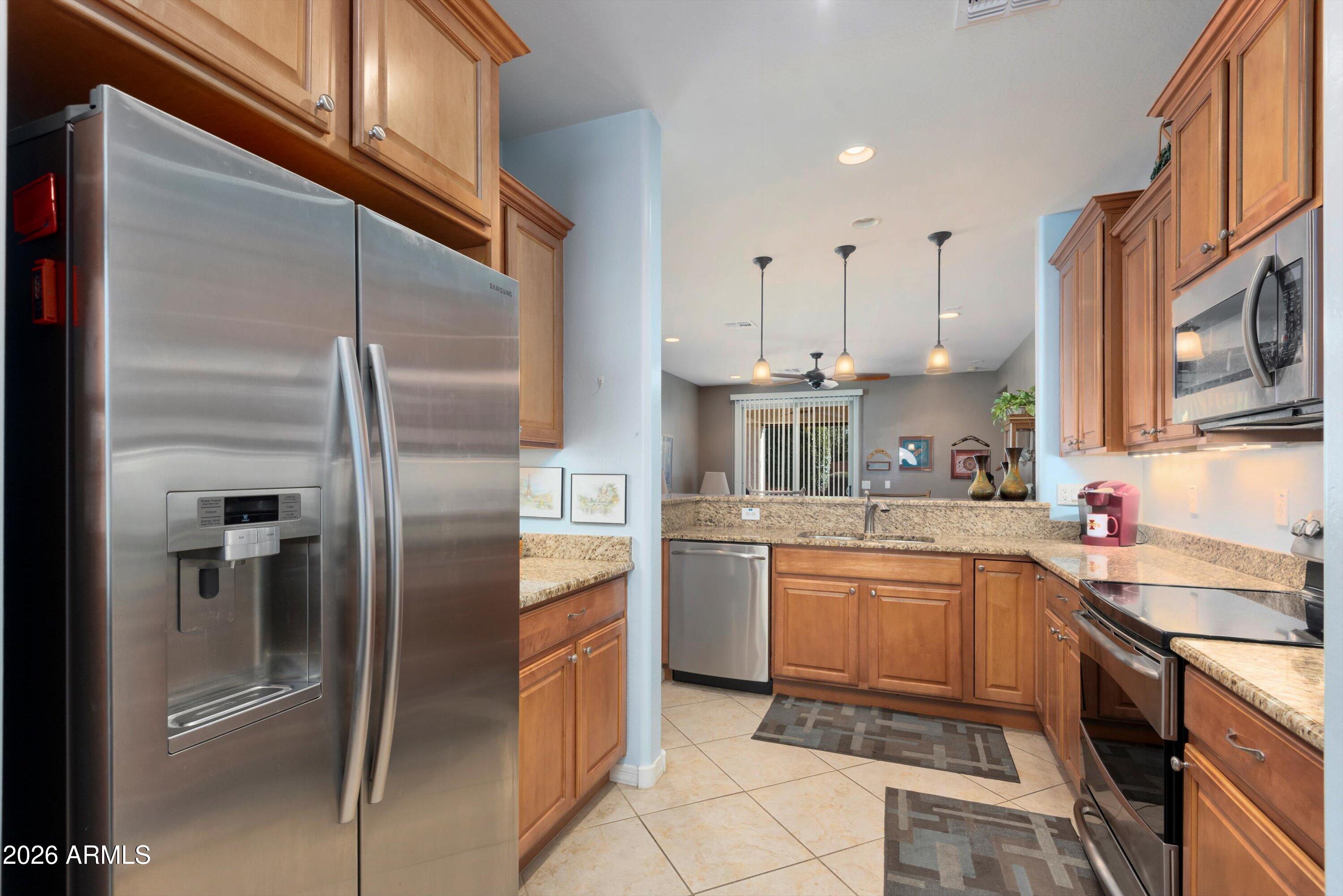 21613 North 261st Avenue Buckeye, AZ 85396 - Photo 8 of 52 a kitchen with stainless steel appliances granite countertop a refrigerator a sink a stove and oven