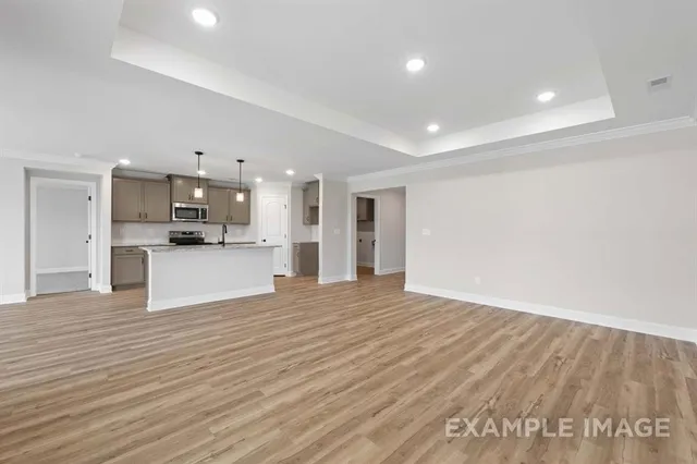 a view of a kitchen with kitchen island a counter top space stainless steel appliances and a ceiling fan