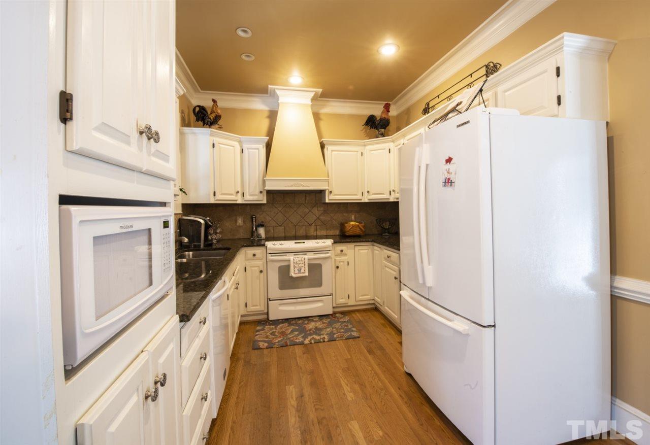 5300 Mitchell Mill Road Wake Forest, NC 27587 - Photo 8 of 27 a kitchen with granite countertop a refrigerator a sink and white cabinets