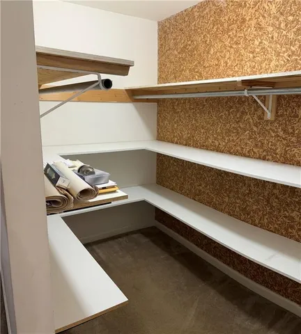 a view of walk in closet with empty racks