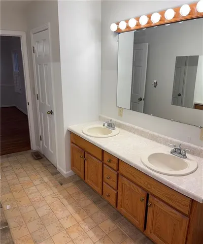 a white bath tub sitting next to a white sink and vanity