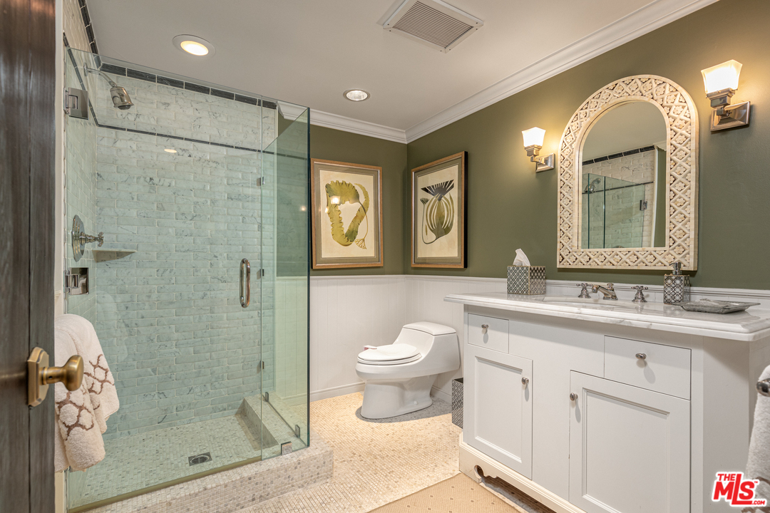 548 Dryad Road Santa Monica, CA 90402 - Photo 13 of 34 a bathroom with a toilet a sink a glass door a shower a mirror and vanity