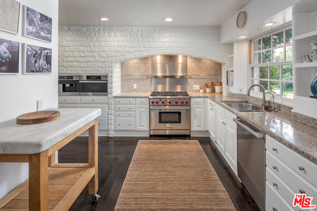 548 Dryad Road Santa Monica, CA 90402 - Photo 6 of 34 a kitchen with stainless steel appliances granite countertop sink stove top oven and cabinets