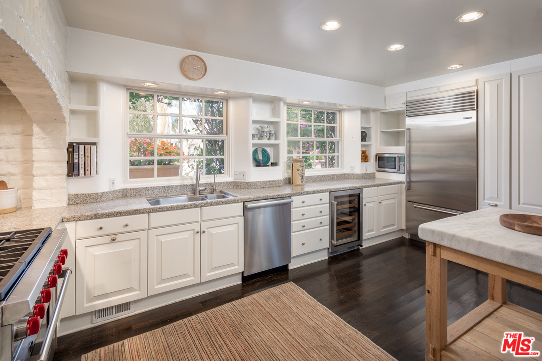 548 Dryad Road Santa Monica, CA 90402 - Photo 9 of 34 a kitchen with stainless steel appliances granite countertop a stove a sink dishwasher a microwave oven and a dining table with wooden floor