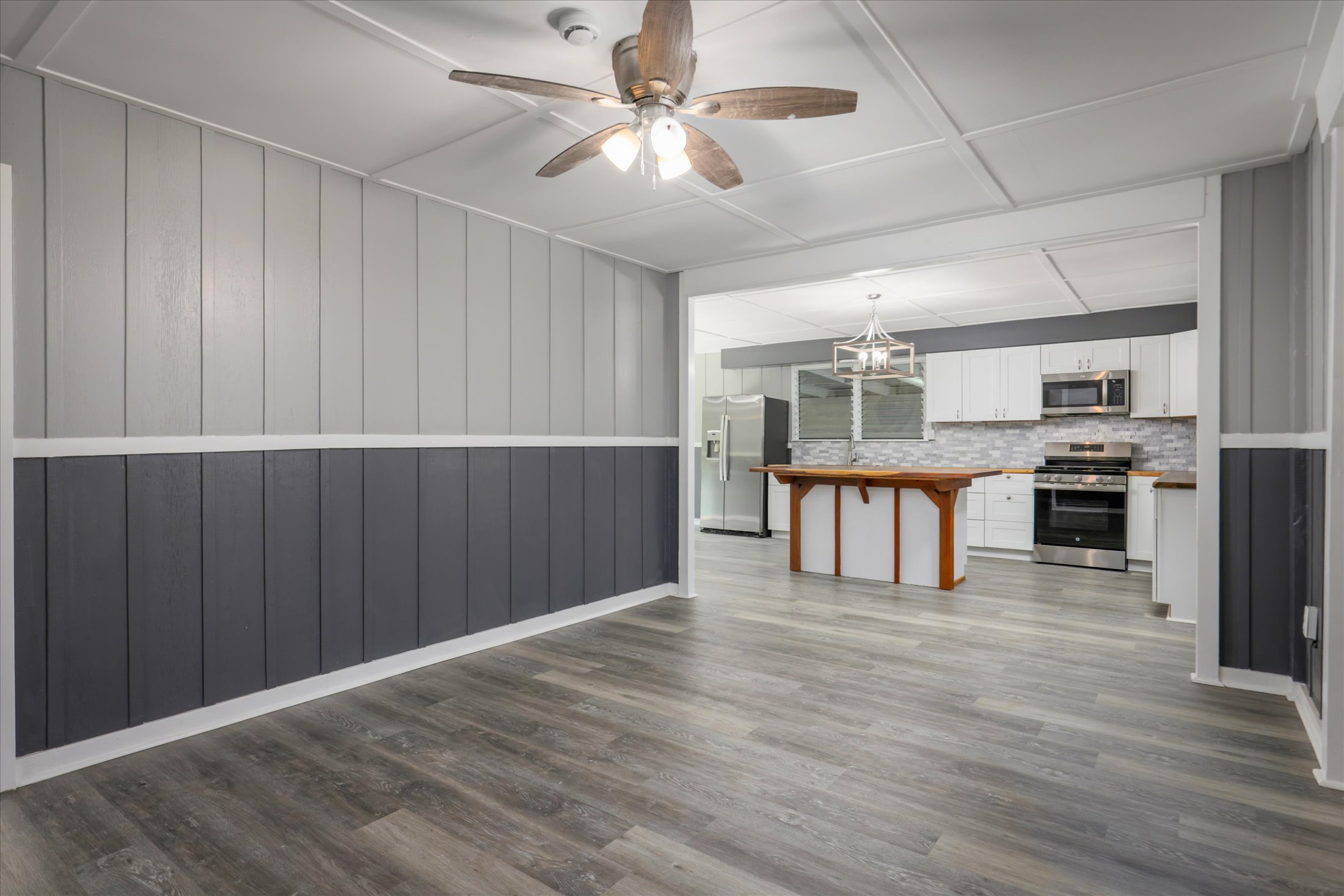 55-545 Hawi Road Hawi, HI 96719 - Photo 20 of 27 a kitchen with stainless steel appliances kitchen island granite countertop a refrigerator a stove and a sink with wooden floors