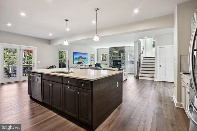 a kitchen with a sink and wooden floor