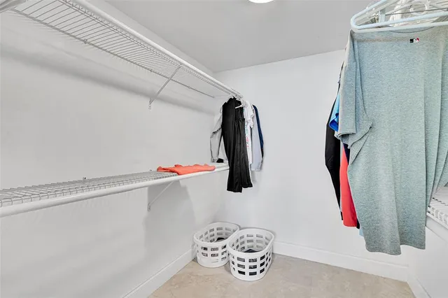 a view of walk in closet with clothes and shoes