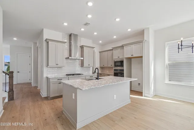 a large kitchen with stainless steel appliances kitchen island granite countertop a stove and a refrigerator