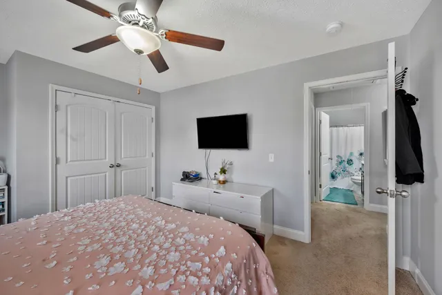 a bedroom with a bed and a flat tv screen on dresser