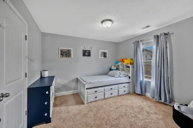 a living room with furniture and a refrigerator