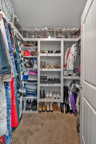 a view of walk in closet with clothes and shoes