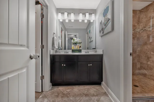 a bathroom with a granite countertop sink a mirror and a shower