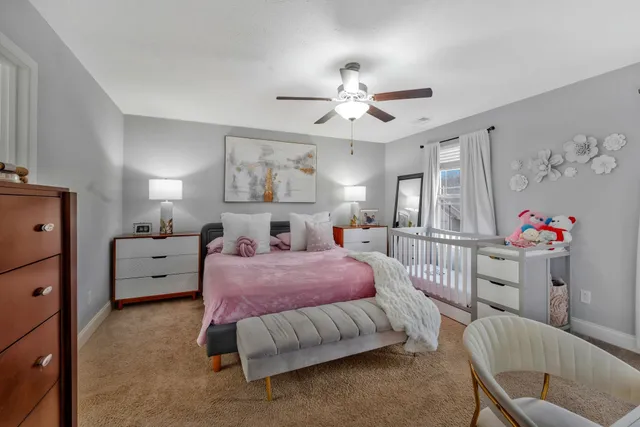 a spacious bedroom with a bed and a chandelier