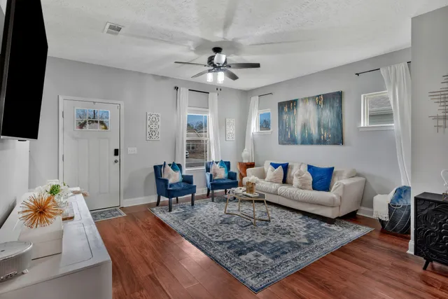 a living room with furniture and wooden floor