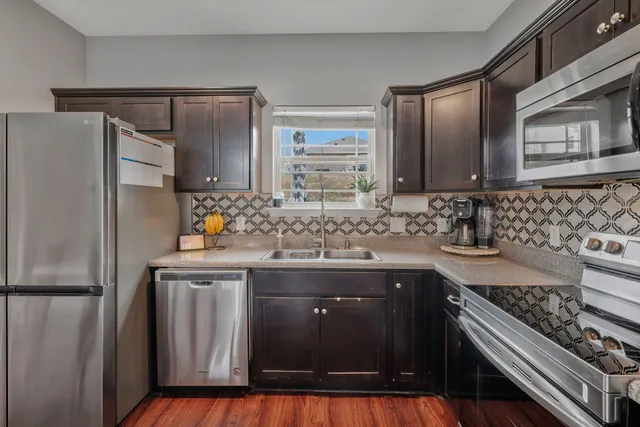 a kitchen with stainless steel appliances granite countertop a sink stove and refrigerator