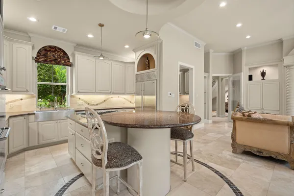 a kitchen with stainless steel appliances granite countertop a stove a refrigerator and a dining table with wooden floors