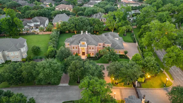 an aerial view of a house with a yard and lake view