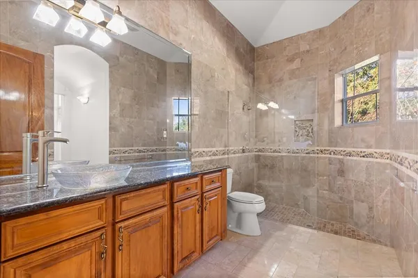a kitchen with stainless steel appliances granite countertop a refrigerator a stove and a sink with wooden floor